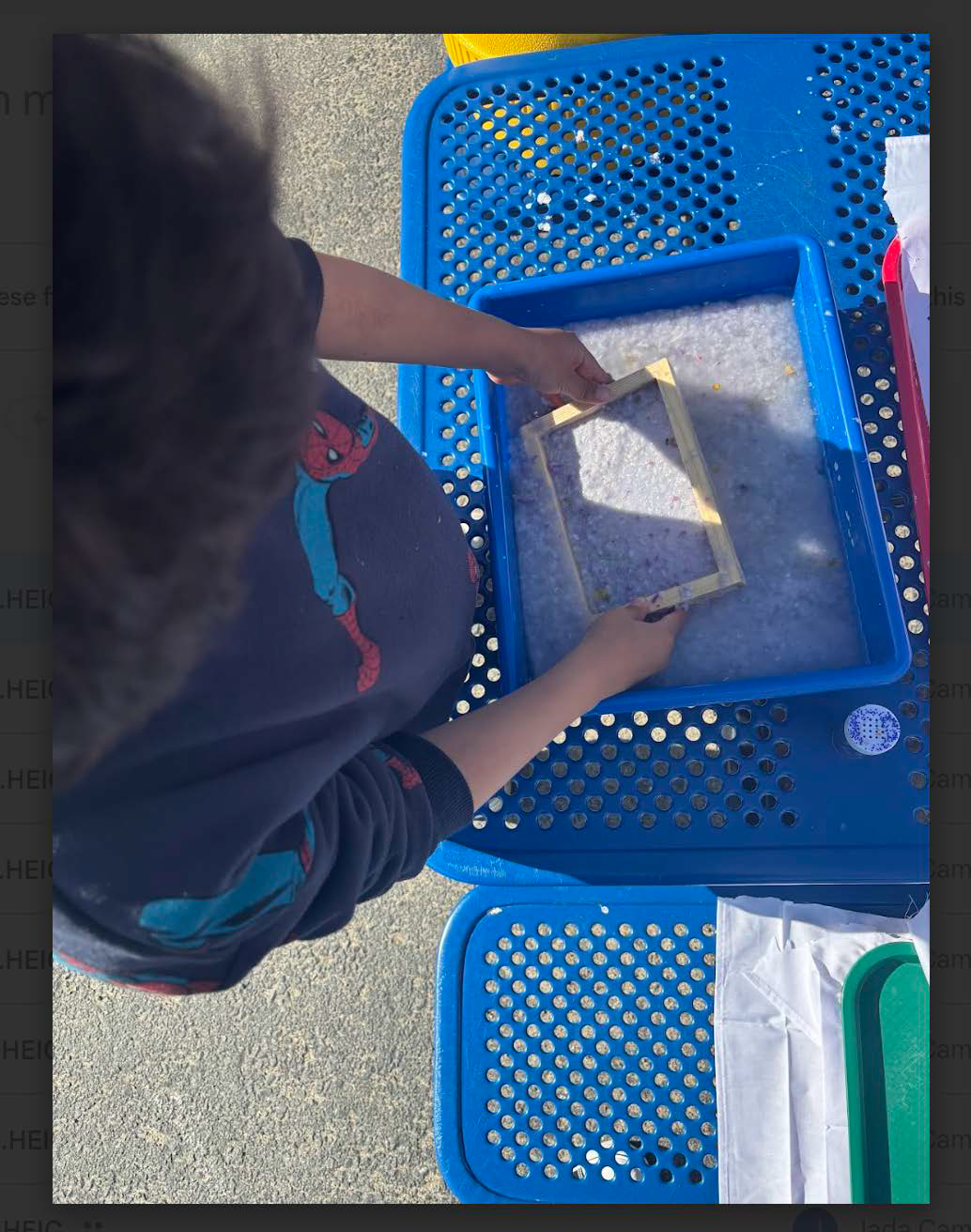 A young boy is playing with a blue plastic tray