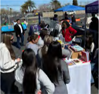 A group of people are standing around a table at a festival.
