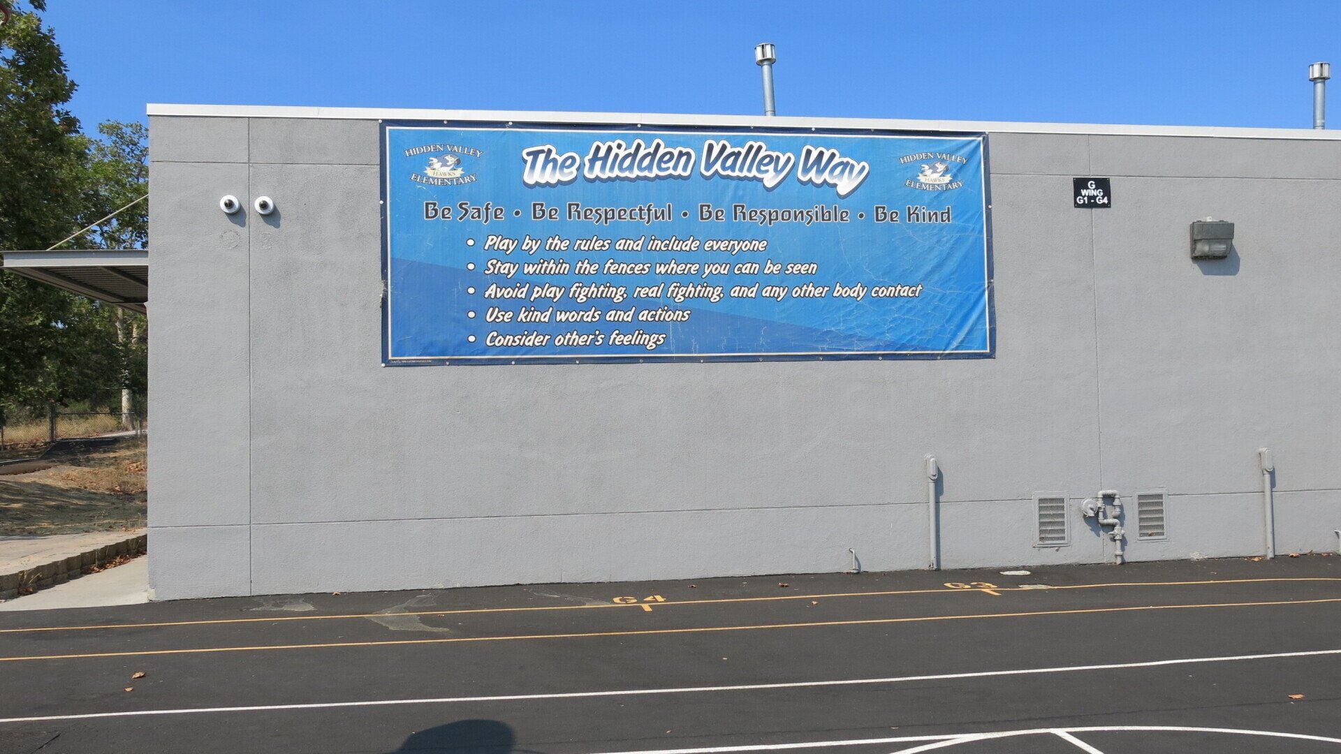 A large blue sign on the side of a building says the middle valley high school
