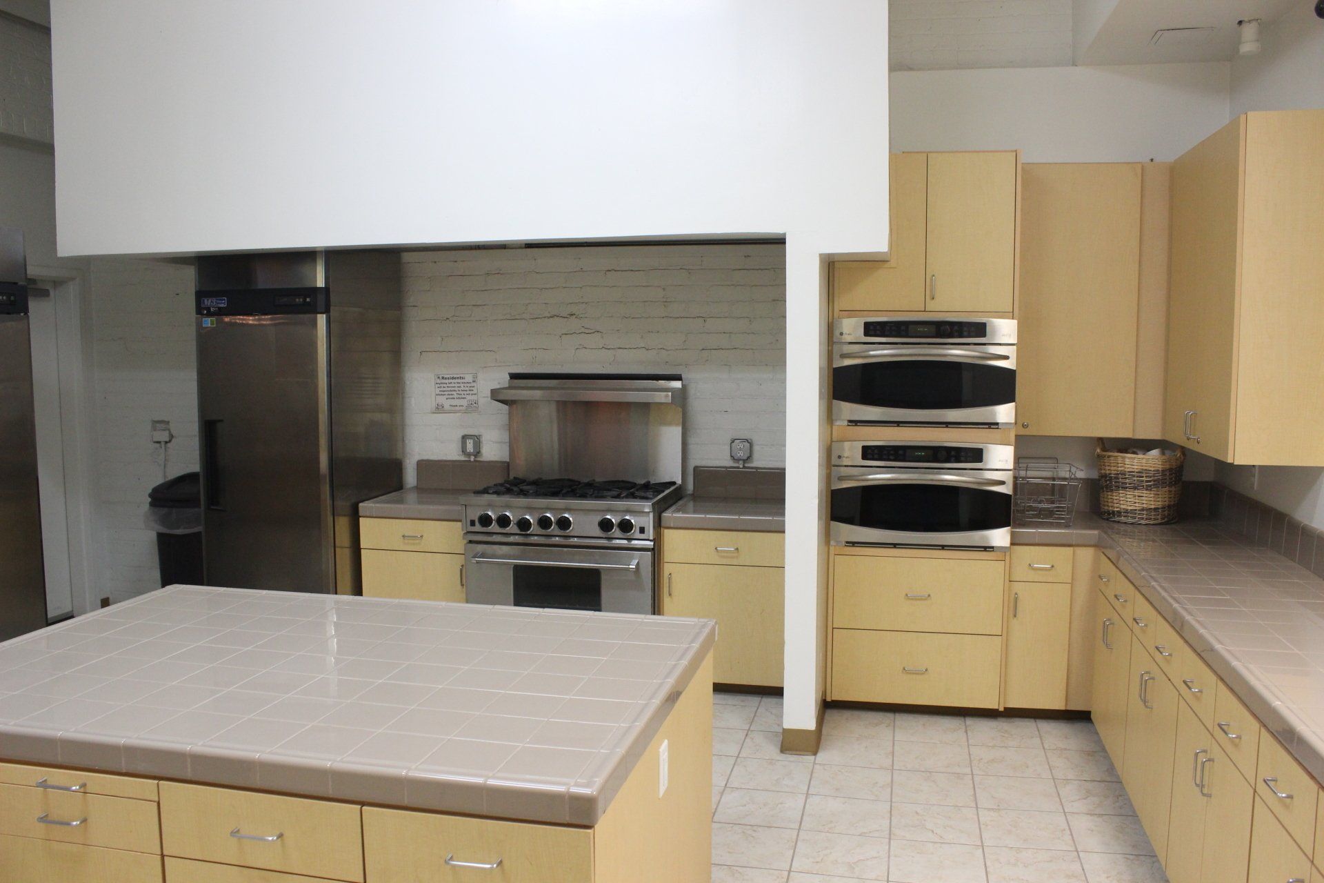 A kitchen with stainless steel appliances and yellow cabinets