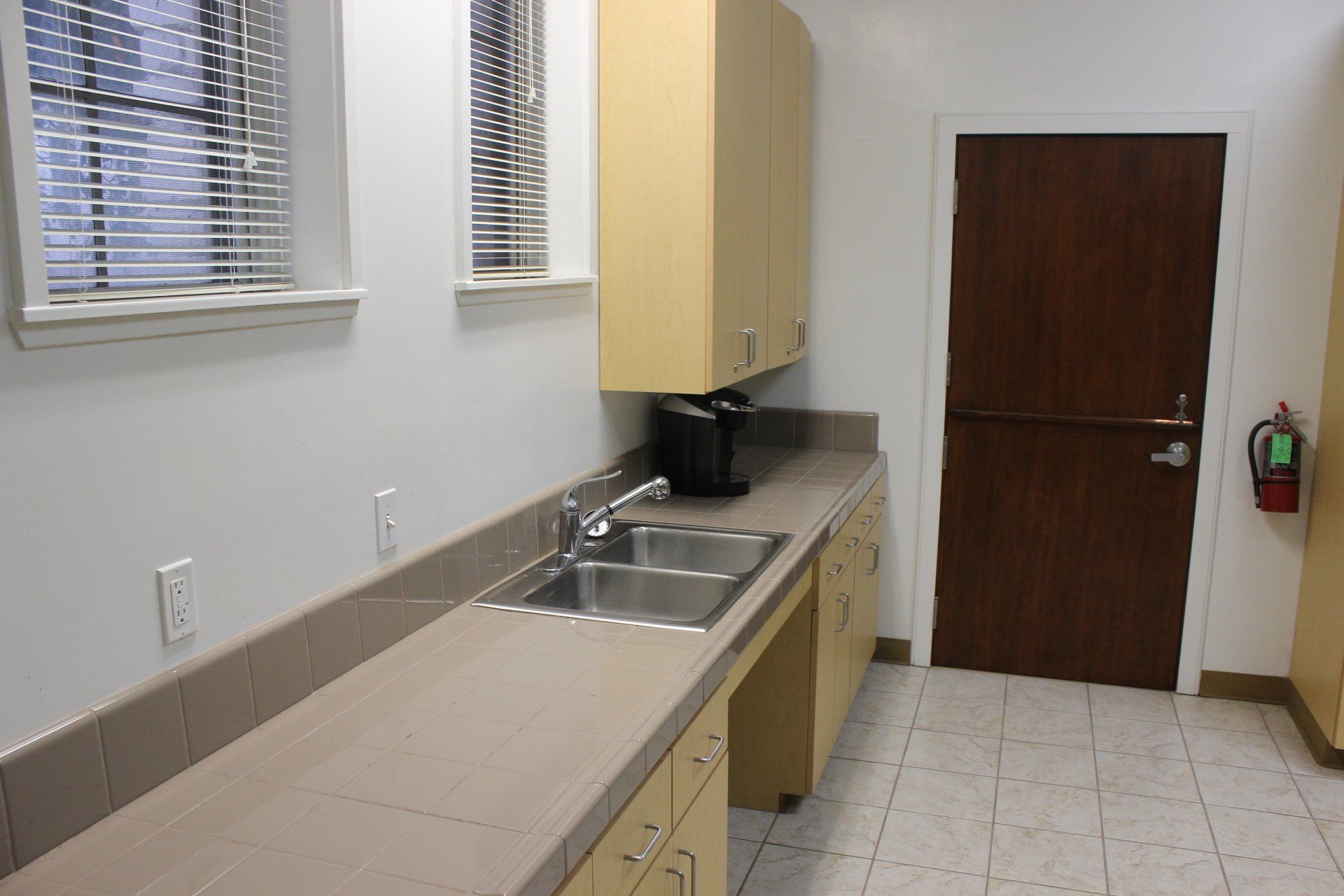 A kitchen with two sinks and a fire extinguisher
