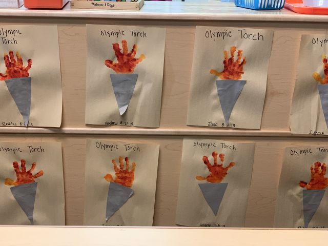 A row of hand prints of the olympic torch