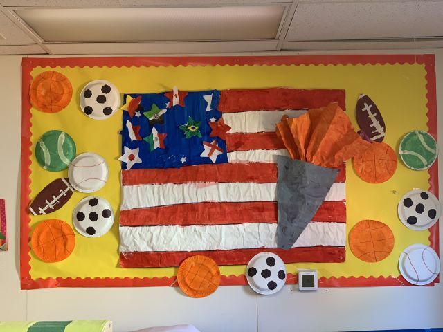 A bulletin board with an american flag and soccer balls on it