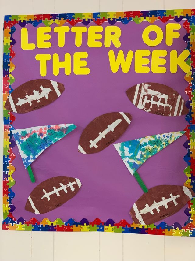 A letter of the week bulletin board with footballs and flags