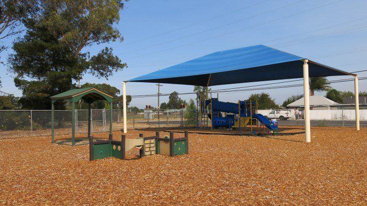 A playground with a blue canopy over it