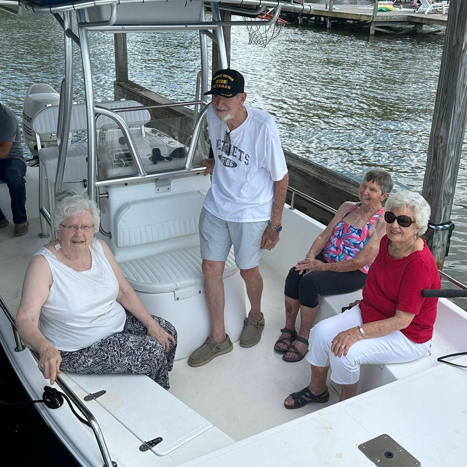 A group of people on a boat one of whom is wearing a shirt that says ' liberty ' on it