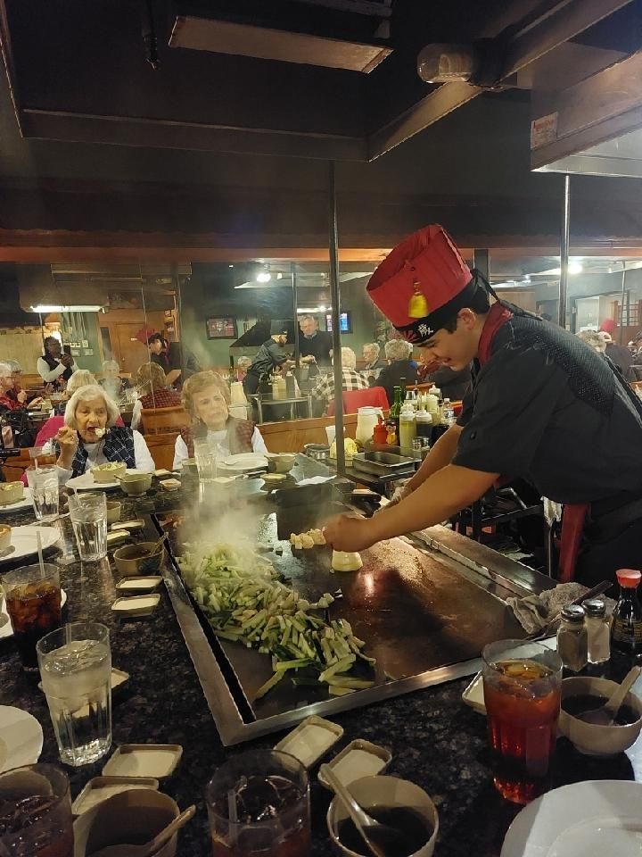 A man is cooking food on a grill in a restaurant.