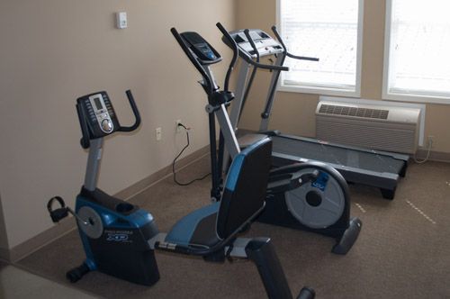 A room with a treadmill and an exercise bike