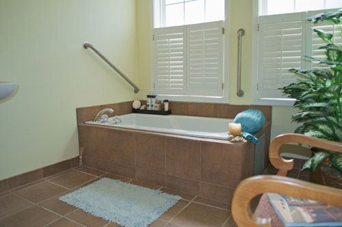 A bathroom with a tub and a chair in it