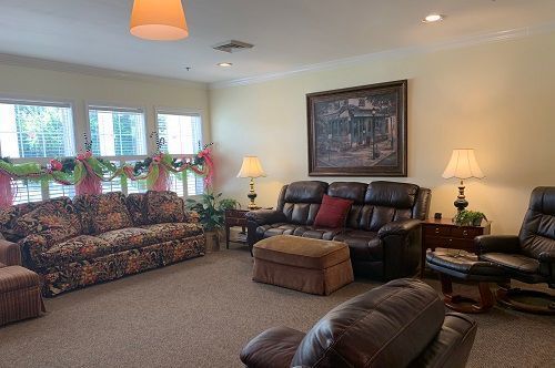 A living room filled with furniture and a painting on the wall.