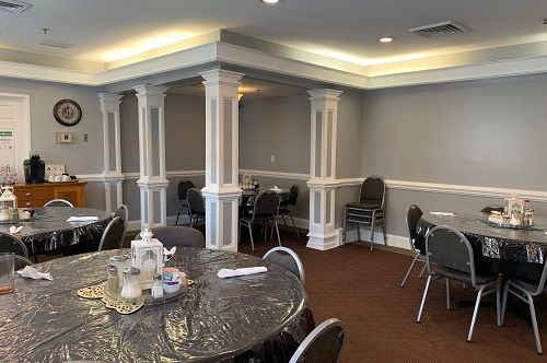 There are many tables and chairs in the room.