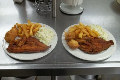 Two plates of fish and french fries on a table