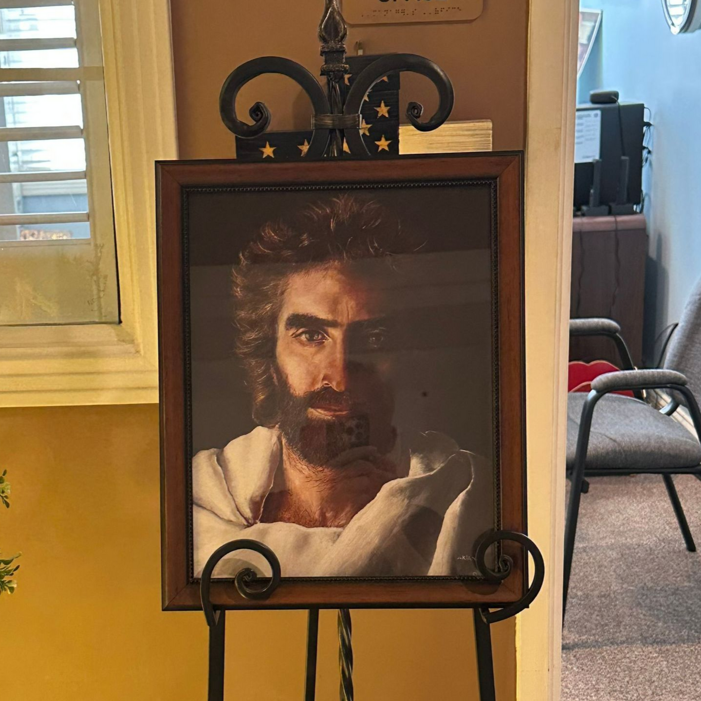 Portrait of Jesus with a beard, in a wooden frame on a black easel.  Independent senior living community near Jacksonville, NC.