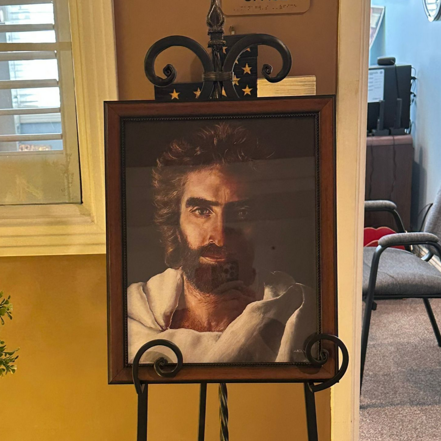 Portrait of Jesus with a beard, in a wooden frame on a black easel.  Independent senior living community near New Bern, NC.
