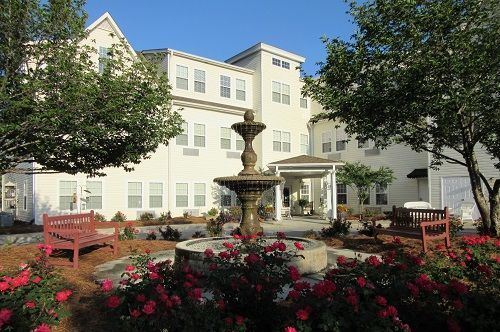 A large white building with a fountain in front of it