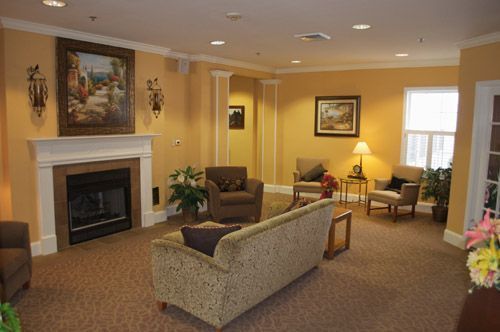 A living room with a couch , chairs and a fireplace