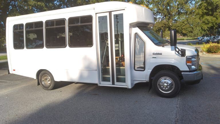 A white bus is parked on the side of the road.