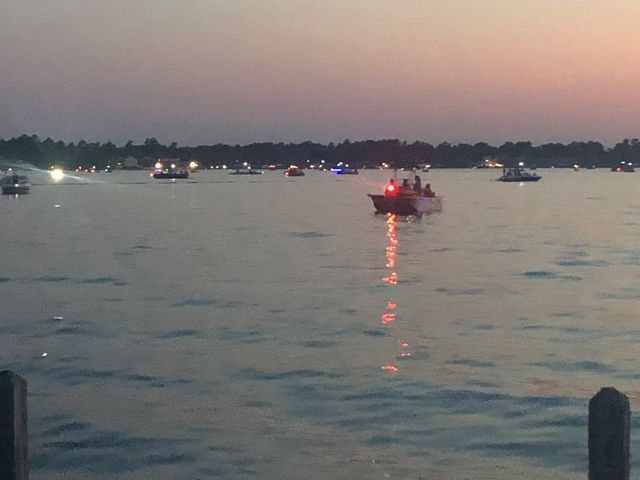A group of boats are floating on a lake at sunset.