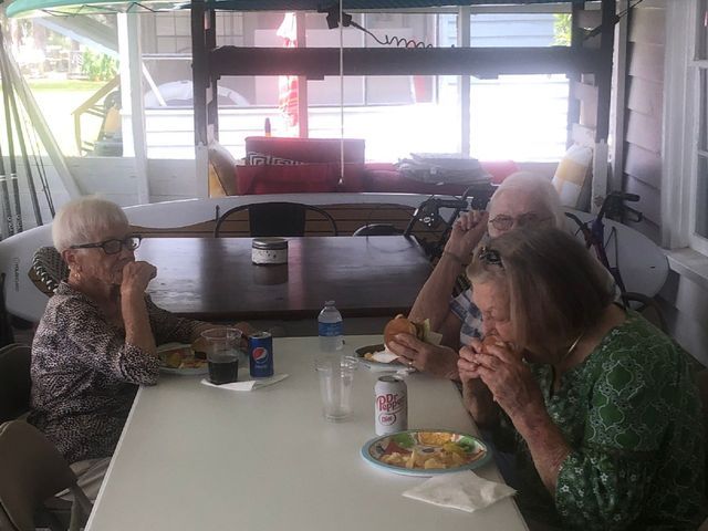 A group of people are sitting at a table eating food.