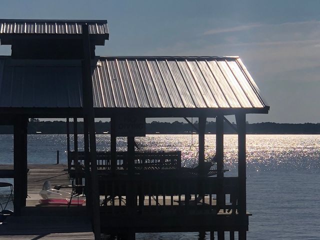 A dock with a metal roof overlooking a body of water