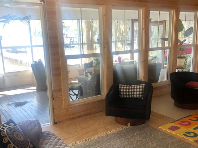 A living room with a lot of windows and chairs