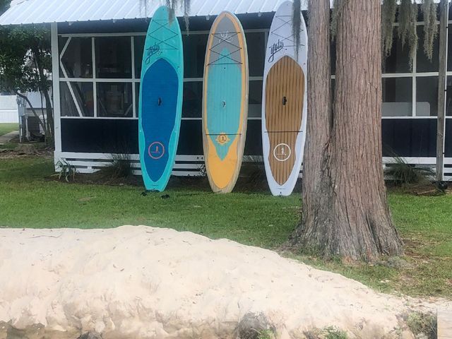 Three surfboards are sitting in front of a screened in porch.