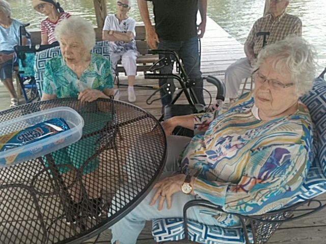 A group of elderly people are sitting around a table.
