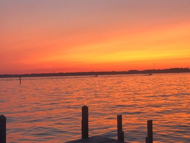 A sunset over a body of water with a dock in the foreground.