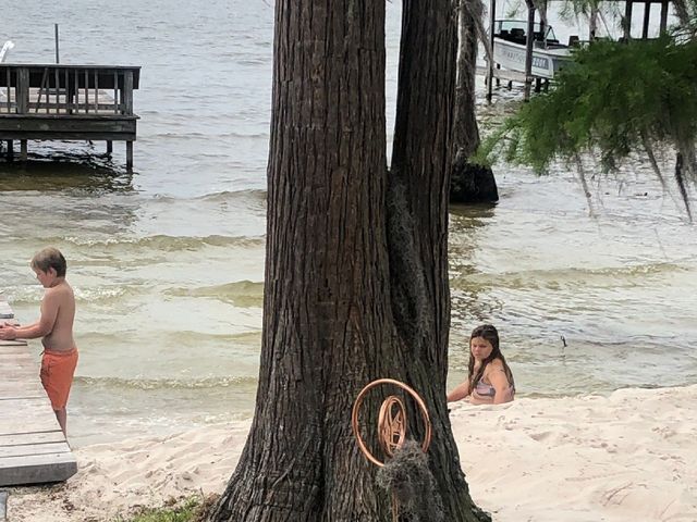 A boy and a girl are playing in the water near a tree