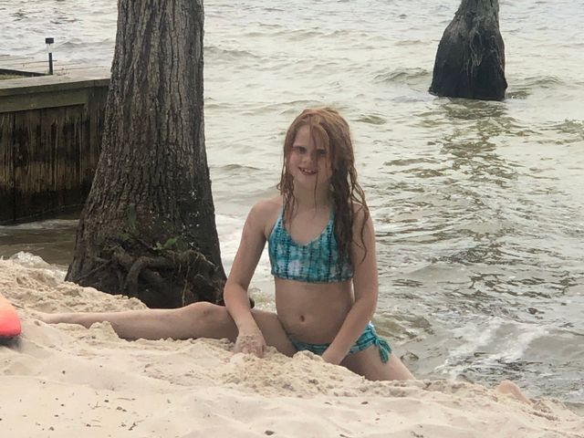 A young girl is playing in the sand