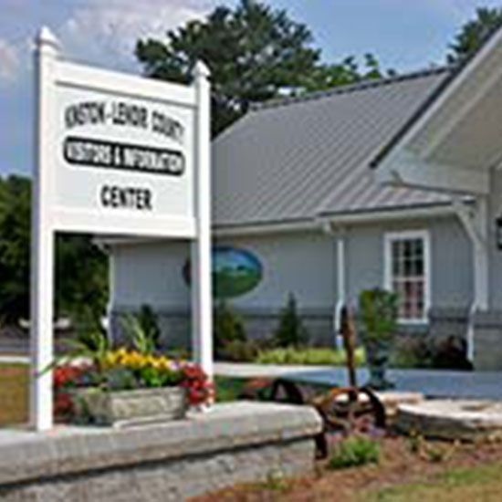 A white sign in front of a building that says center