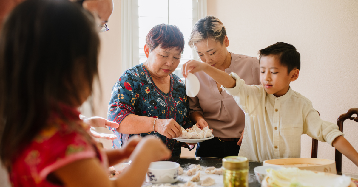 A group of people are sitting around a table eating food.
