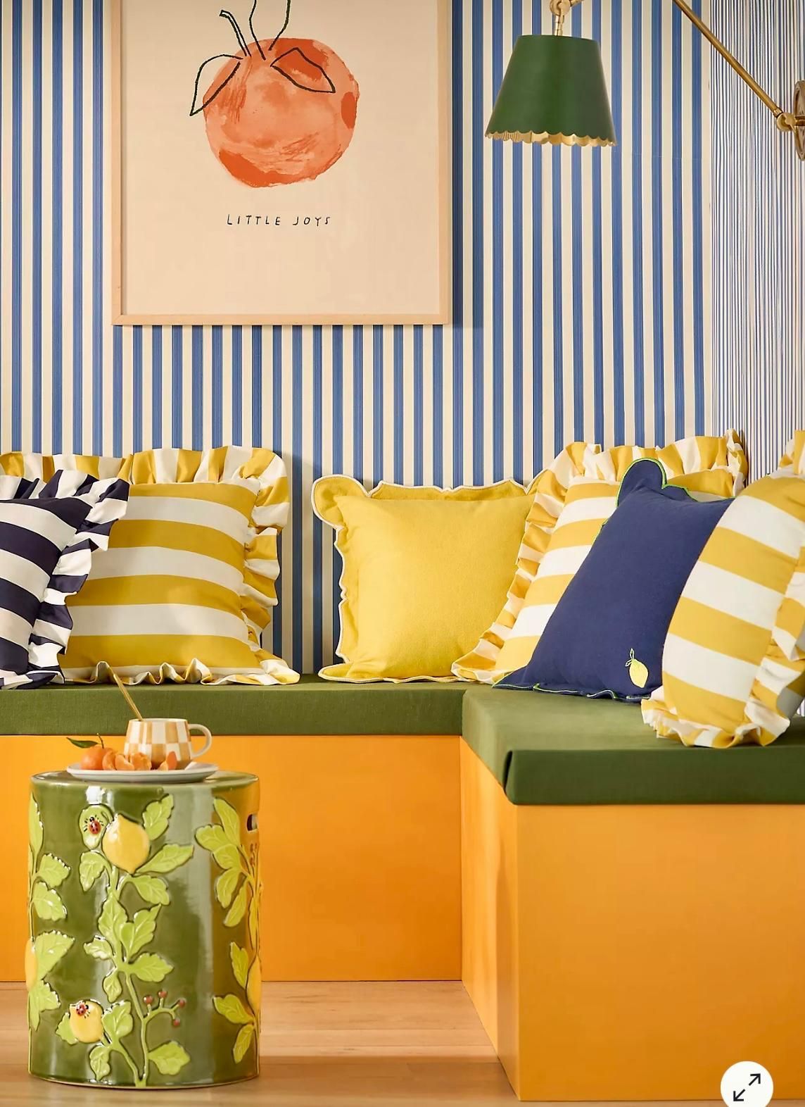Outdoor seating area from Anthropology. Blue, yellow and white striped cushions & ceramic side table