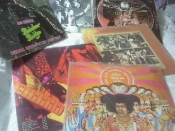 Assortment of colorful vinyl record album covers spread out on a surface.
