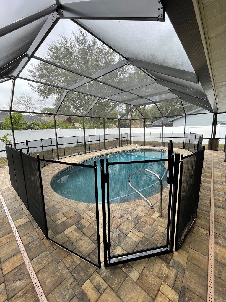A swimming pool surrounded by a screened in area and a gate.