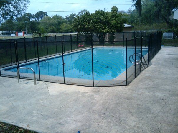 A large swimming pool with a black fence around it