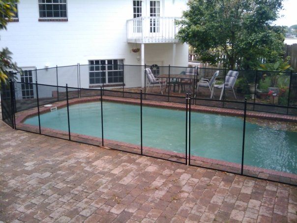 A large swimming pool with a black fence around it
