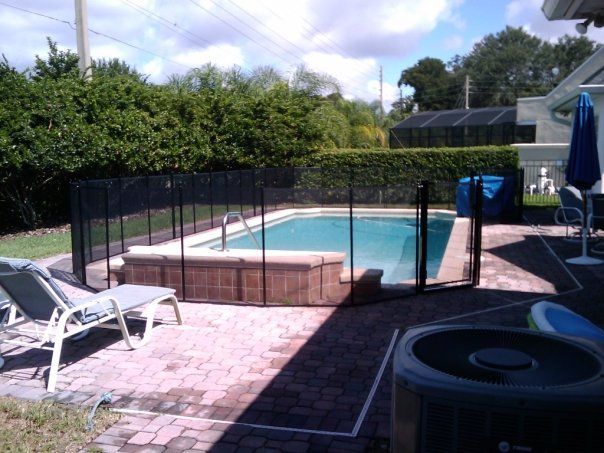 A backyard with a fence around a swimming pool