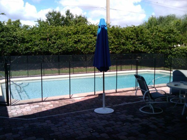 A pool with a blue umbrella in front of it