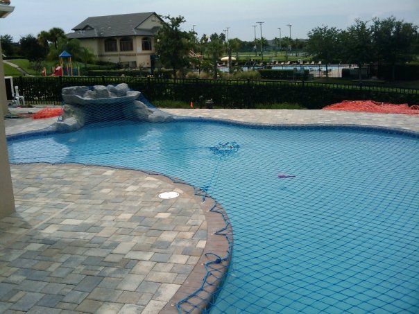 A large swimming pool with a house in the background