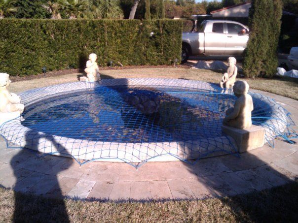 A white truck is parked in front of a swimming pool