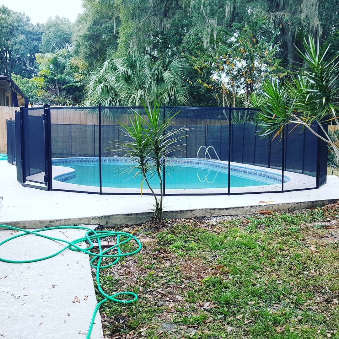 A swimming pool with a fence around it in a backyard.
