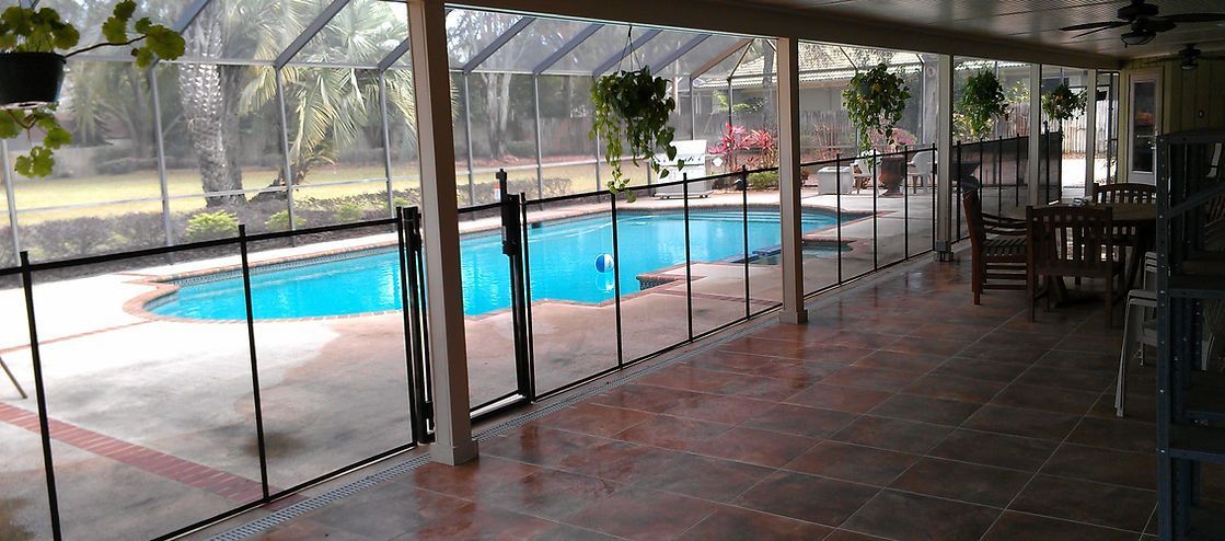 A screened in porch with a swimming pool in the background.