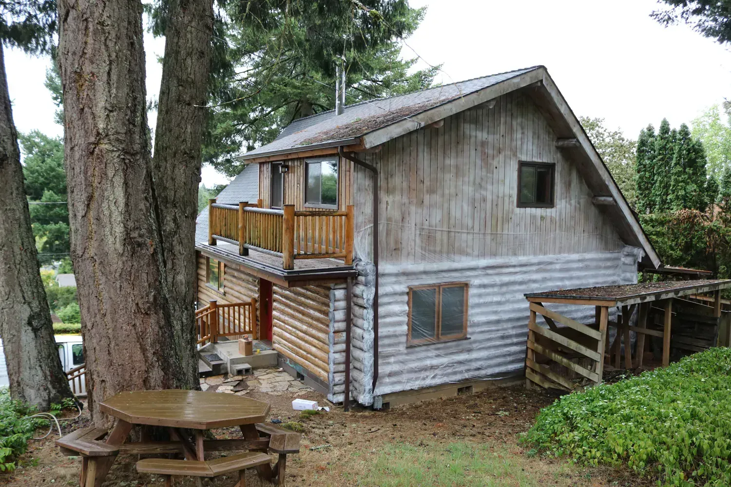 A log cabin with a picnic table in front of it