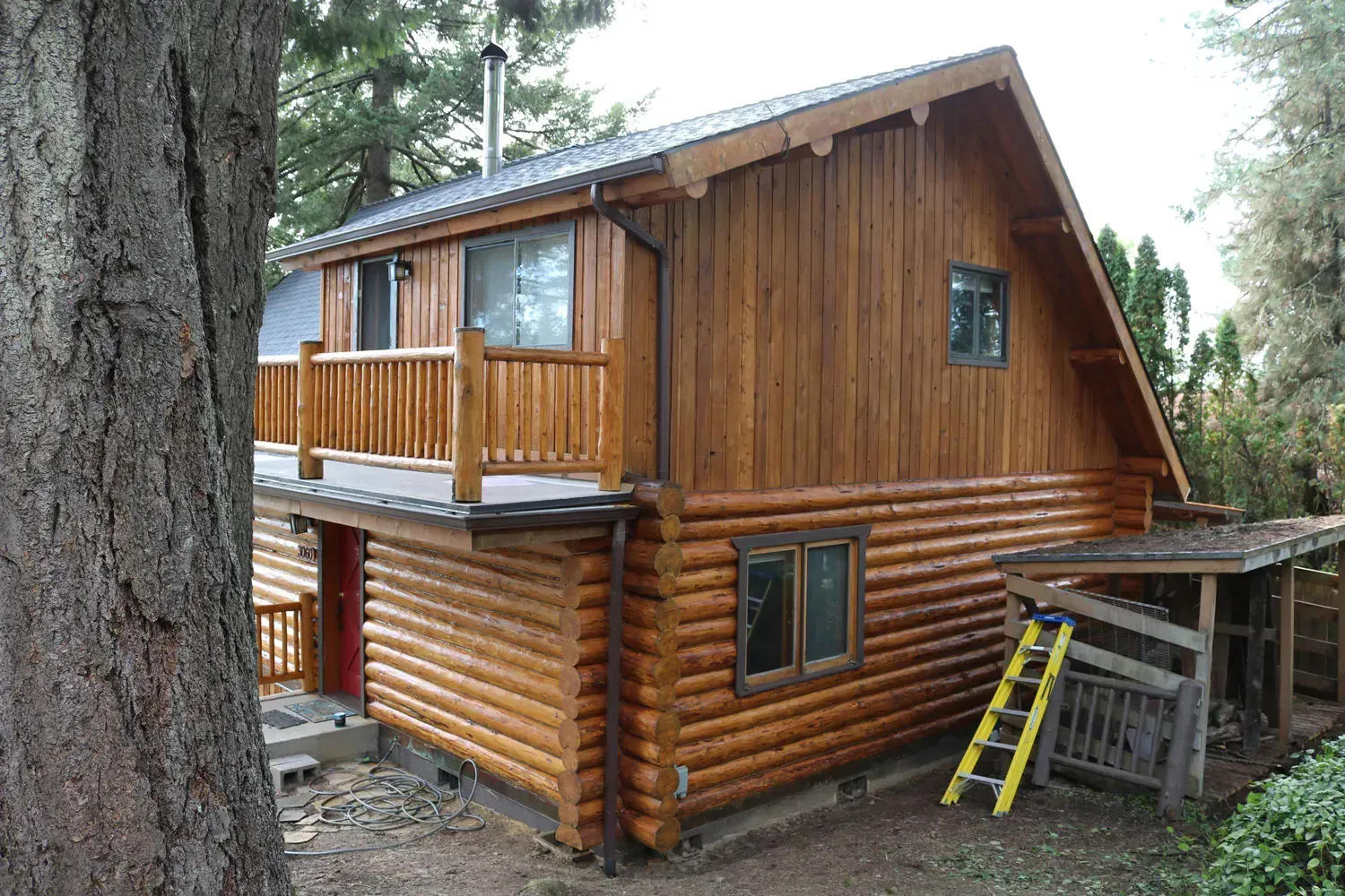 A log cabin with a ladder in front of it
