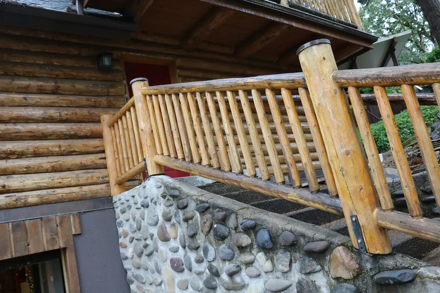 A log cabin with a wooden railing and stairs leading up to it.