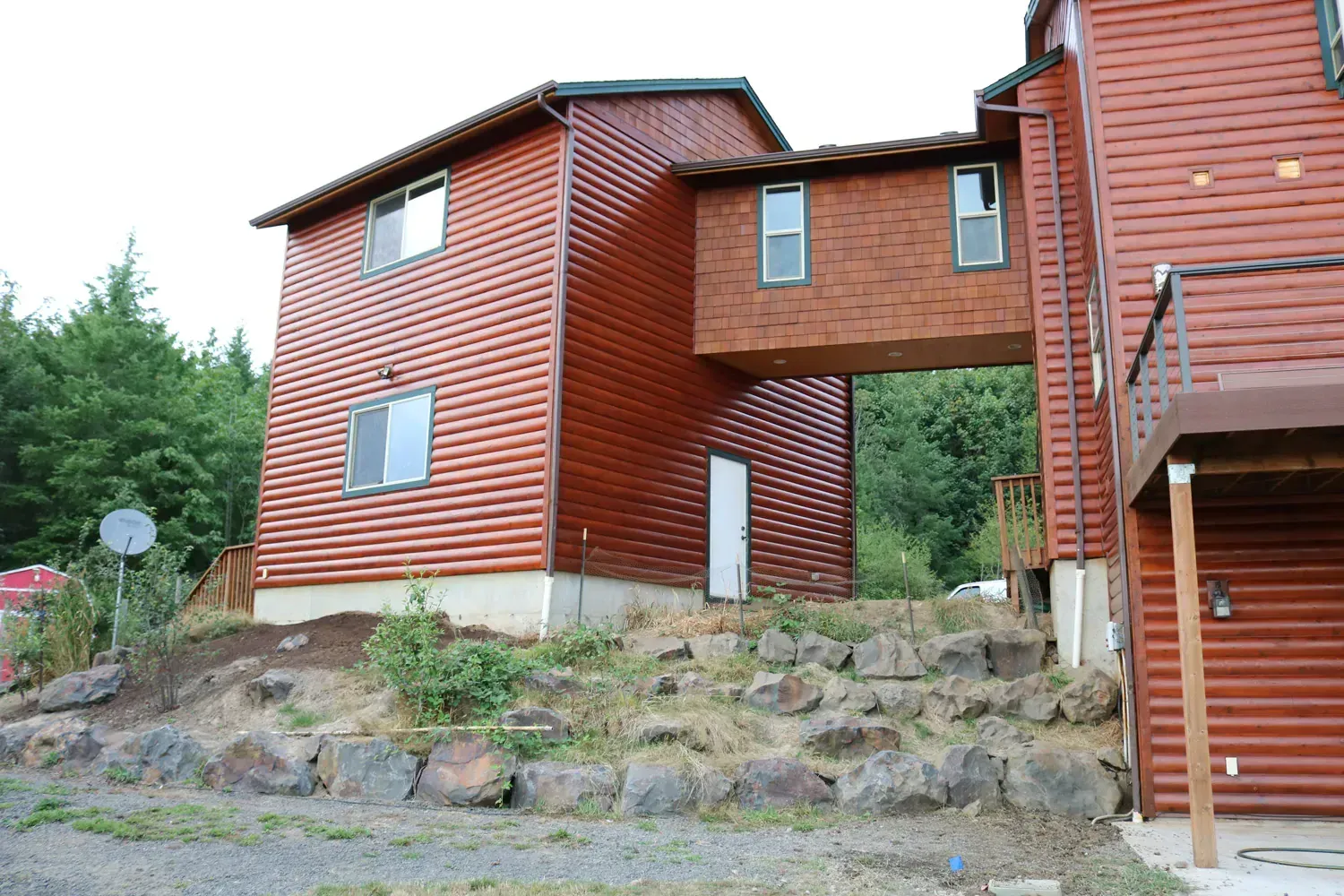 A wooden house with a bridge between the two buildings