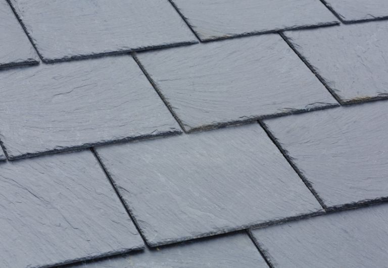 Gray slate roof with two dormer windows.