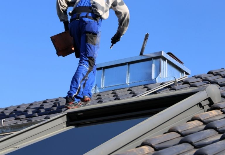 Close-up of gray corrugated metal roofing, with curved ridges and openings.