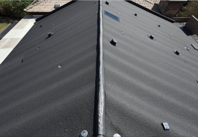 Person welding roofing material with a hot air gun, using red and white gloves.